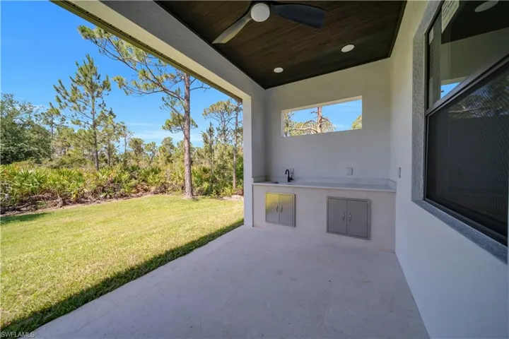 View of patio with an outdoor kitchen, a ceiling fan, and a sink