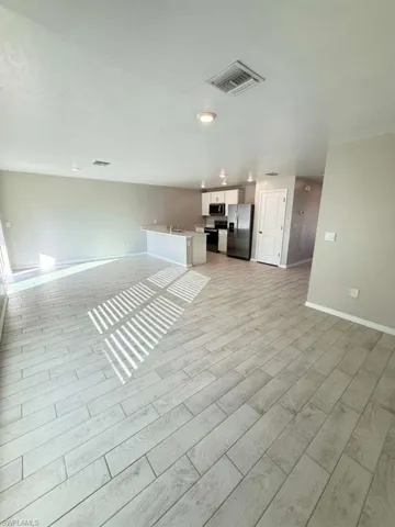 Unfurnished living room with baseboards and wood finish floors