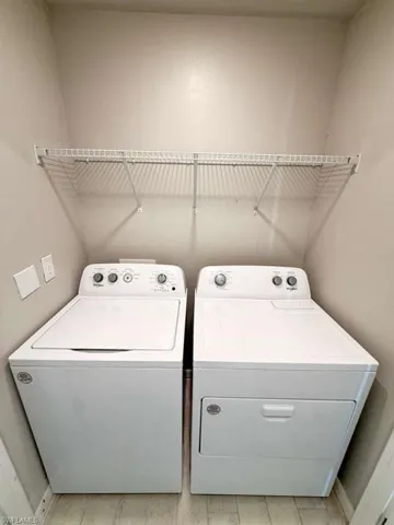 Laundry room featuring washing machine and dryer and light wood-style flooring