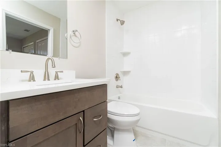 Bathroom with tile patterned floors, toilet, vanity, shower / tub combination, and visible vents