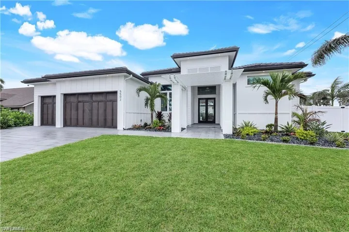 View of front of home featuring a front yard, driveway, and an attached garage