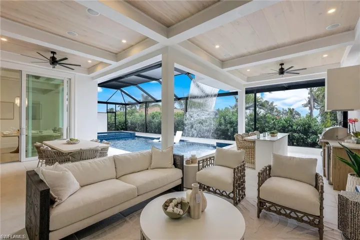 View of patio / terrace featuring ceiling fan, a sunroom, glass enclosure, area for grilling, and a pool with connected hot tub