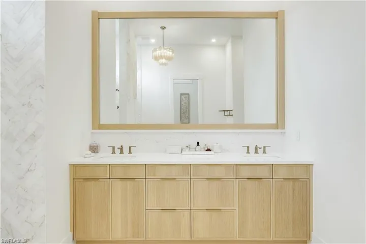 Bathroom featuring double vanity and a chandelier
