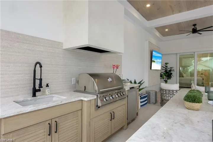 View of patio featuring a ceiling fan and an outdoor kitchen