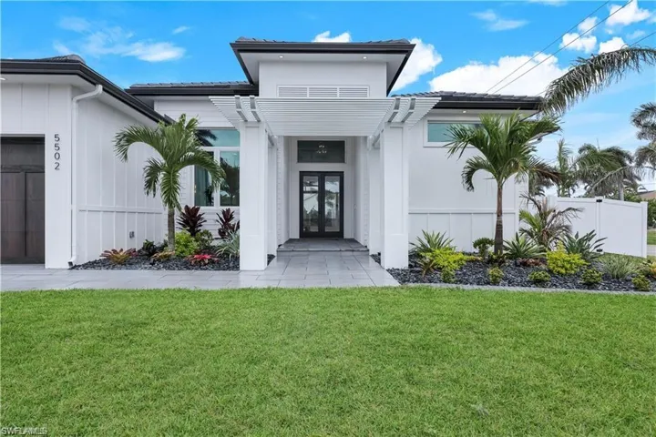 Doorway to property with french doors, a yard, and an attached garage