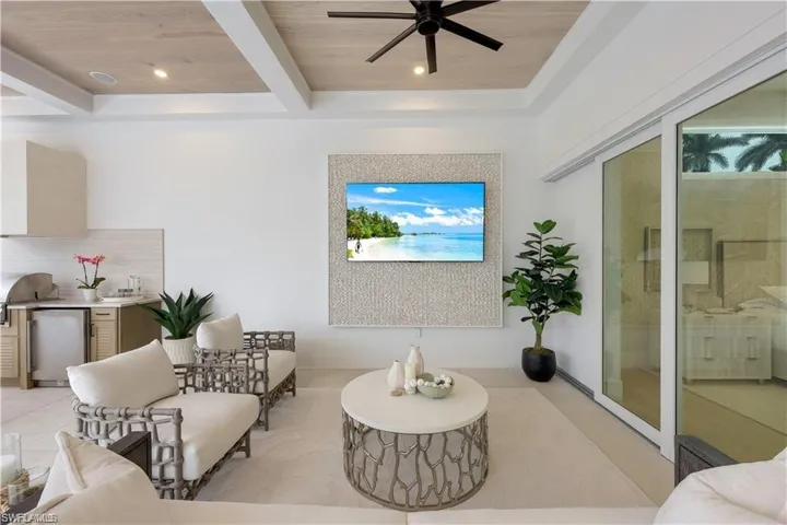 Sitting room with ceiling fan, a wood ceiling with exposed beams, and recessed lighting
