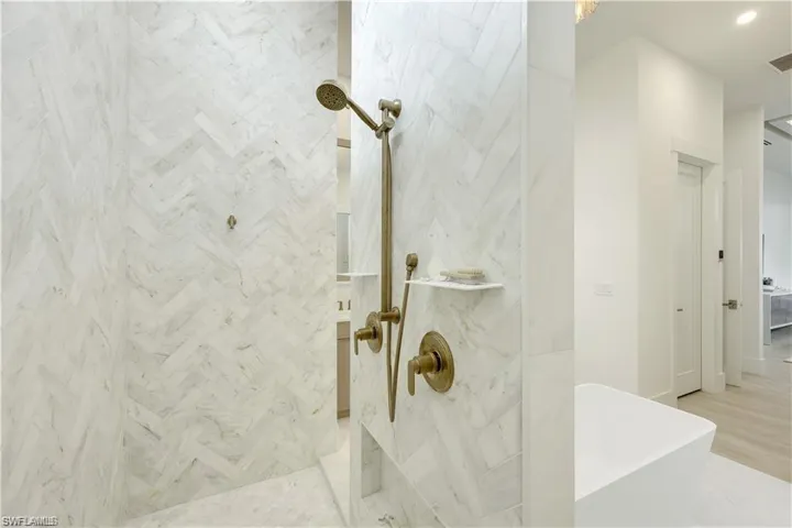 Bathroom with a freestanding bath, walk in shower, and recessed lighting