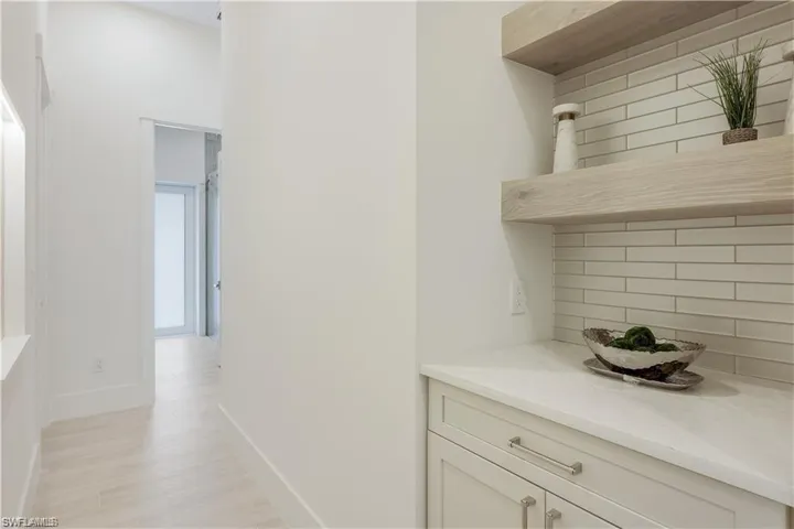 Corridor with baseboards and light wood-style floors