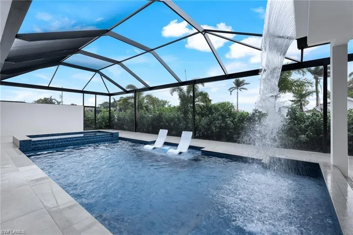 Integrated pool / hot tub featuring a sunroom, a lanai, and a patio