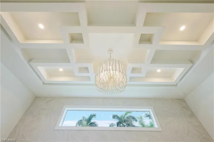 Detailed view of hanging lights, coffered ceiling, and wallpapered walls
