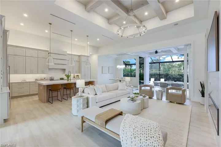 Living room with coffered ceiling, recessed lighting, light wood finished floors, a sunroom, and a ceiling fan