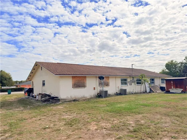Back of property featuring a yard and stucco siding