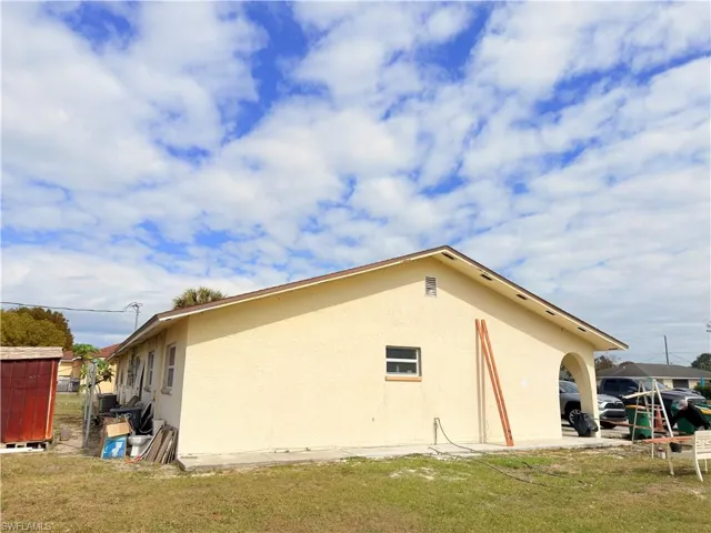 View of property exterior featuring stucco siding and a yard