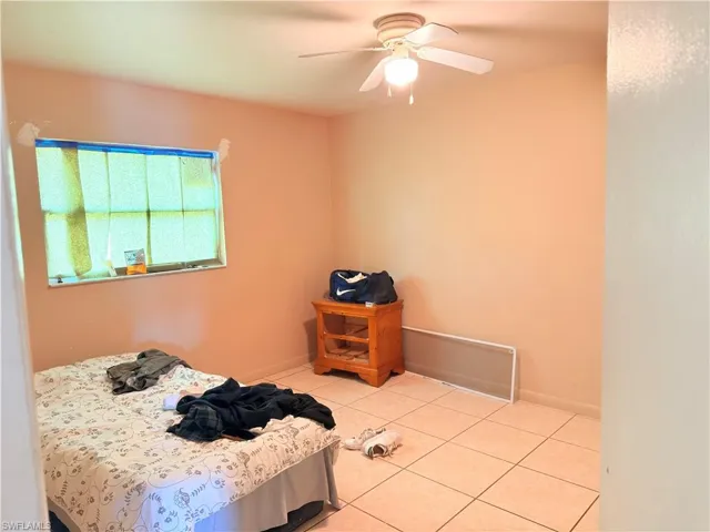 Bedroom with light tile patterned floors and ceiling fan