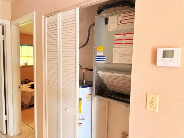 Utility room featuring gas water heater and heating unit