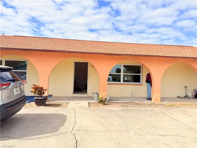 Doorway to property with stucco siding and roof with shingles