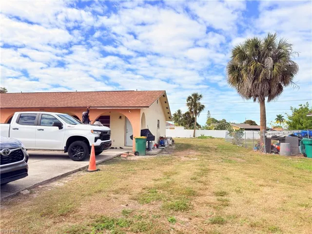 View of side of property with stucco siding and a shingled roof