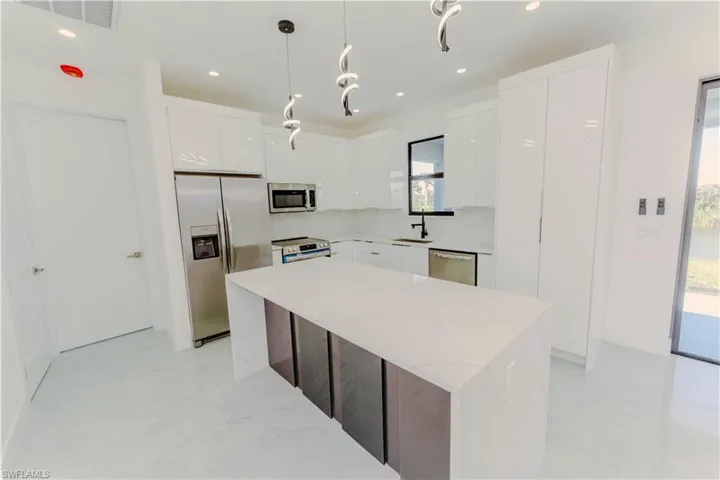 Kitchen featuring visible vents, modern cabinets, tasteful backsplash, white cabinetry, and stainless steel appliances