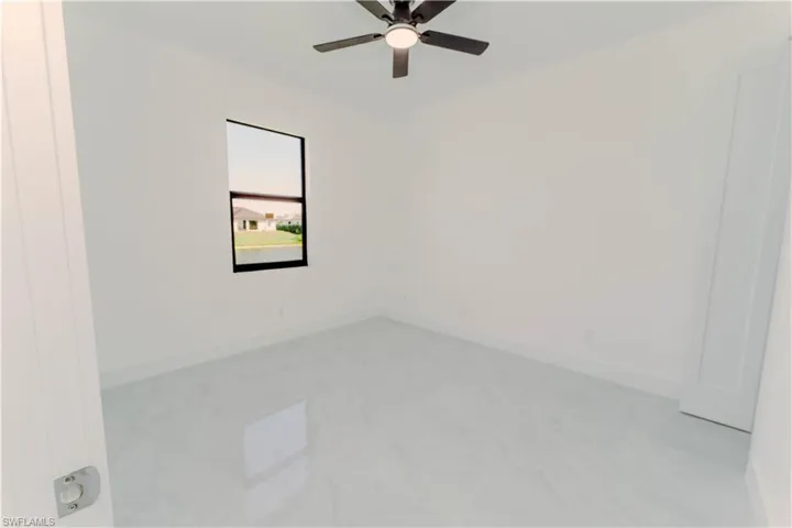 Spare room featuring baseboards and ceiling fan