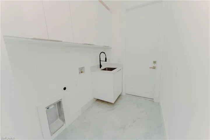 Laundry room featuring hookup for a washing machine, cabinet space, hookup for an electric dryer, and a sink