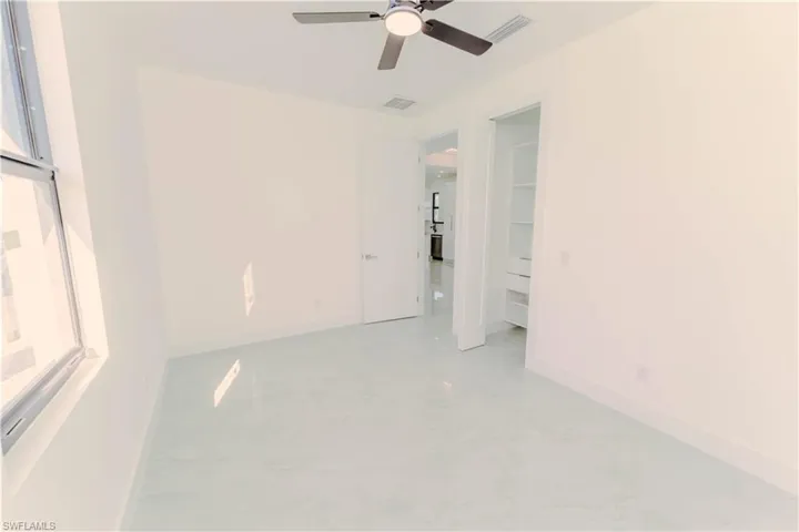 Spare room with visible vents, baseboards, and a ceiling fan