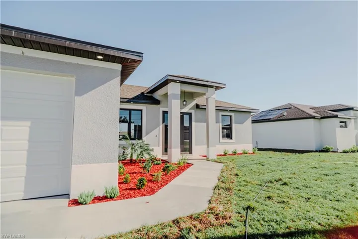 View of front of house featuring stucco siding, a front yard, and roof with shingles