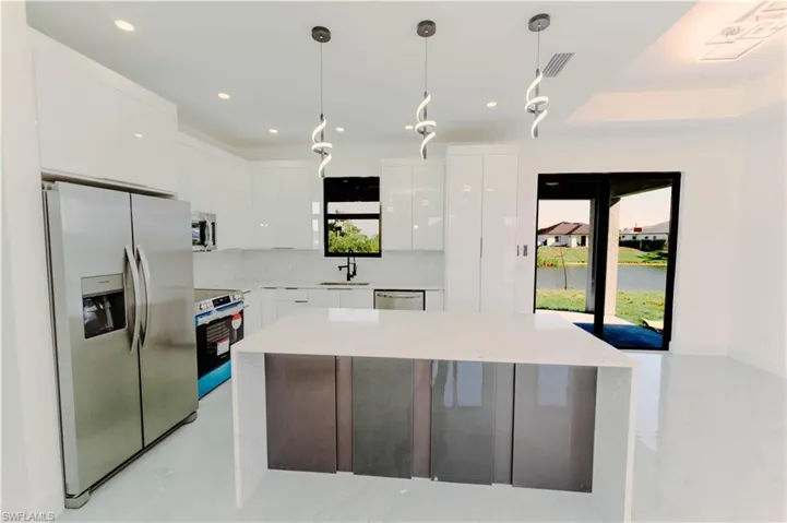 Kitchen featuring a sink, modern cabinets, white cabinetry, and stainless steel appliances
