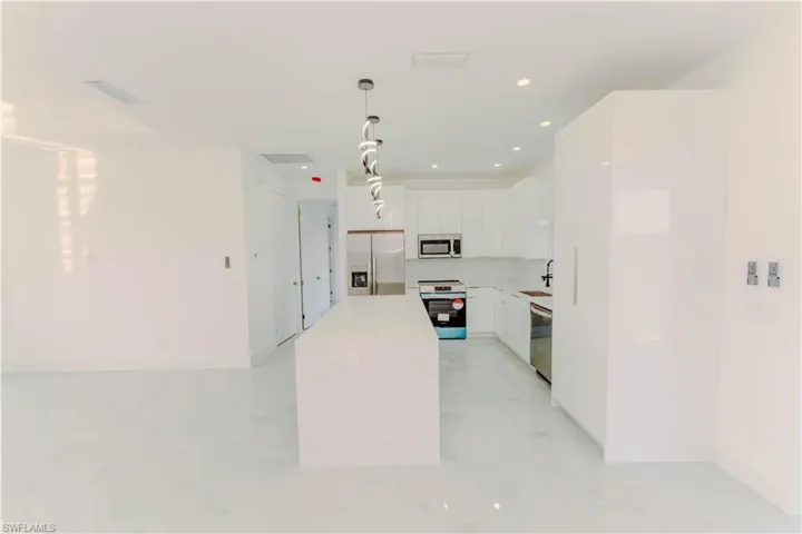 Kitchen featuring visible vents, white cabinets, stainless steel appliances, and a sink