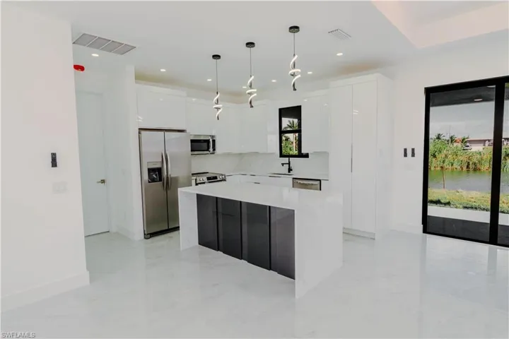 Kitchen with visible vents, modern cabinets, pendant lighting, appliances with stainless steel finishes, and white cabinets