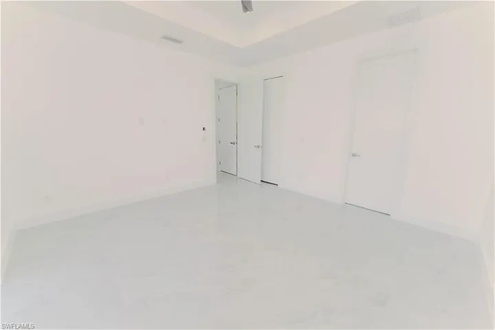 Unfurnished room with a tray ceiling, baseboards, and visible vents