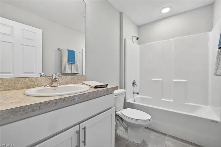 Full bathroom featuring vanity, shower / bathtub combination, and light tile patterned floors