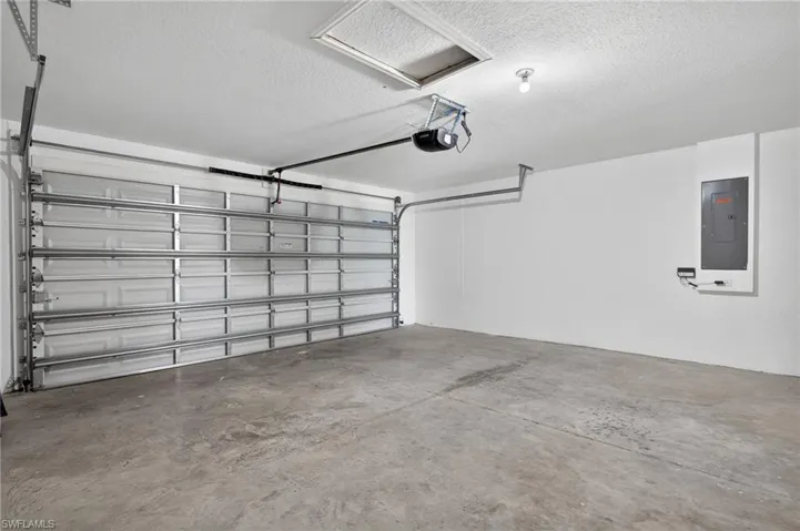 Garage featuring electric panel and a garage door opener