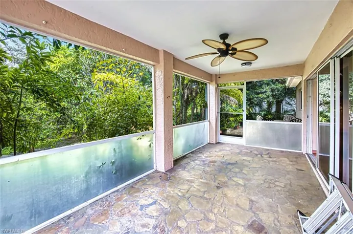 Unfurnished sunroom featuring ceiling fan