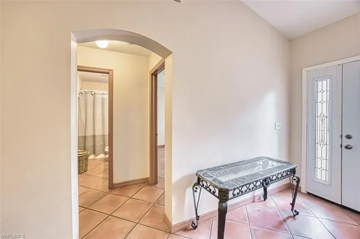 Foyer entrance featuring arched walkways and light tile patterned floors