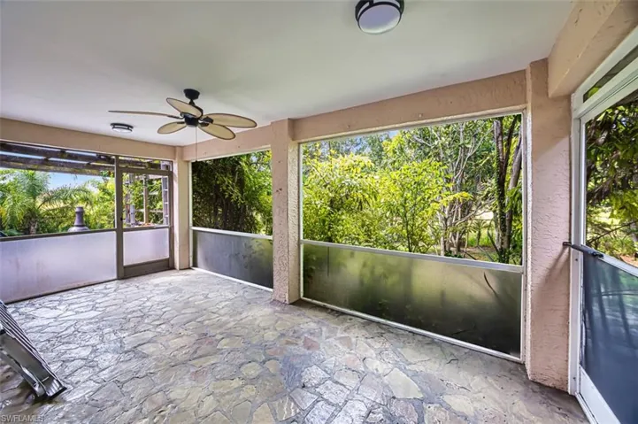 Unfurnished sunroom featuring a ceiling fan and plenty of natural light