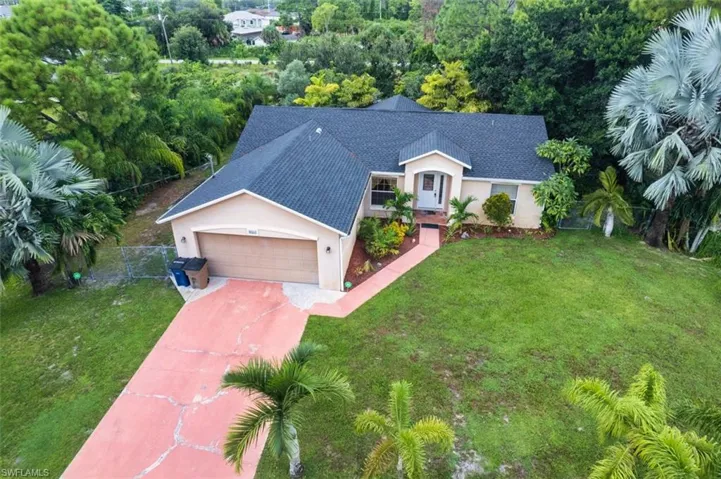 View of front of property with roof with shingles, stucco siding, concrete driveway, and a garage