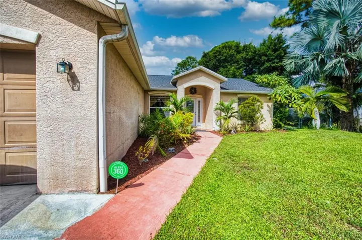 Entrance to property featuring a lawn and stucco siding