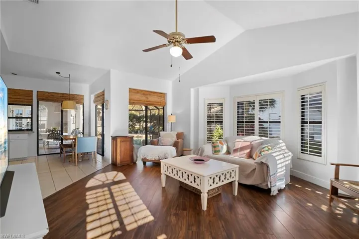Living room featuring dark wood finished floors, ceiling fan, and a high ceiling