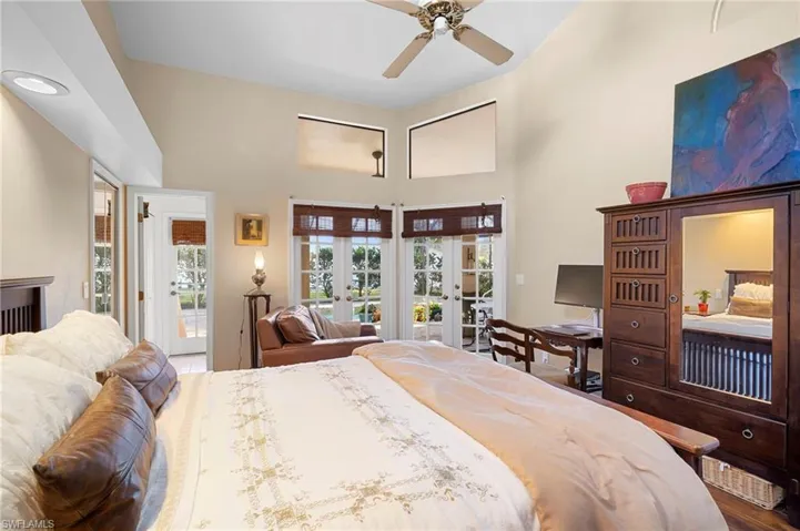 Bedroom with access to outside, french doors, a ceiling fan, and a high ceiling