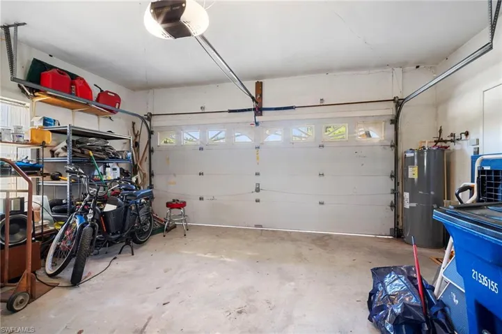 Garage featuring a garage door opener and water heater