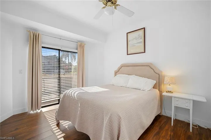 Bedroom with dark wood-style flooring and a ceiling fan