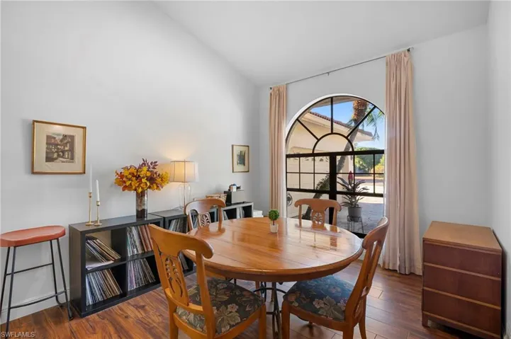 Dining area with vaulted ceiling and hardwood / wood-style floors