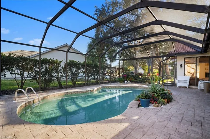 Swimming pool featuring glass enclosure, a sunroom, and a patio