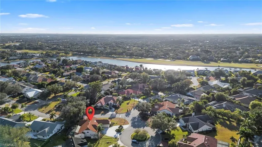 Aerial view of property's location with a large body of water and nearby suburban area