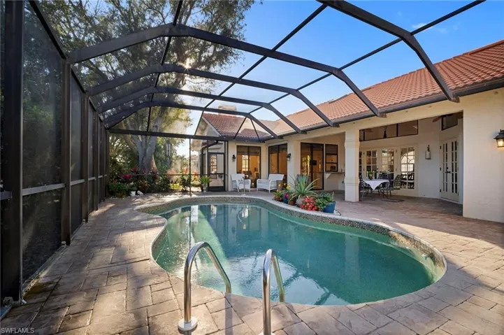 Swimming pool featuring a sunroom, glass enclosure, a patio area, and french doors