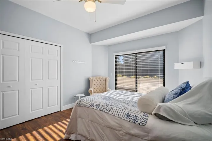 Bedroom featuring a closet, dark wood-style flooring, and ceiling fan