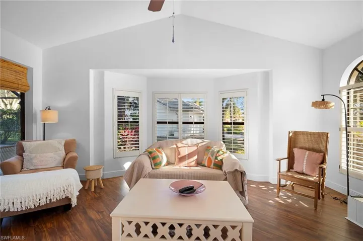 Living area featuring dark wood-style flooring and a ceiling fan