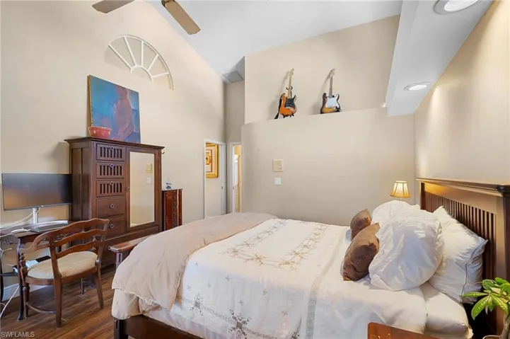 Bedroom featuring wood finished floors, lofted ceiling, and ceiling fan