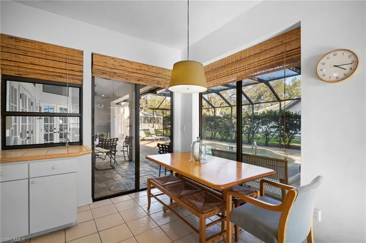 Dining room featuring a sunroom, light tile patterned floors, and healthy amount of natural light