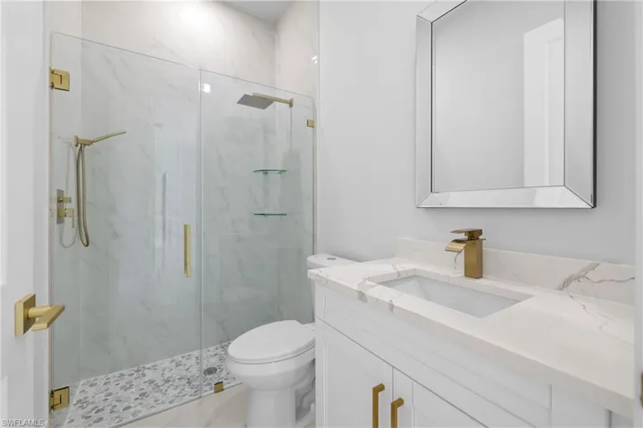Bathroom with toilet, walk in shower, and vanity
